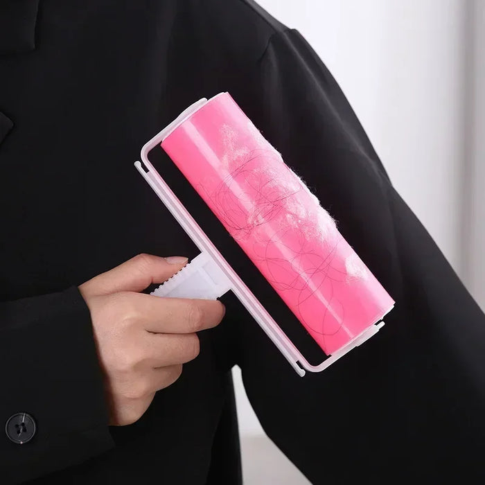 Rolo adesivo rosa remove pelos e fiapos de roupa preta, acessório de limpeza prático.