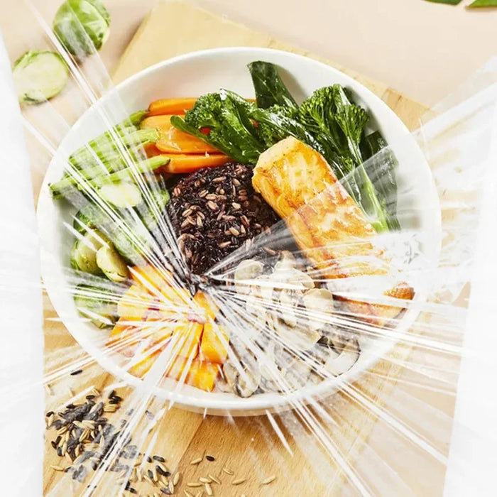 Bowl de salmão grelhado com arroz preto, legumes frescos e sementes, embalado em plástico.